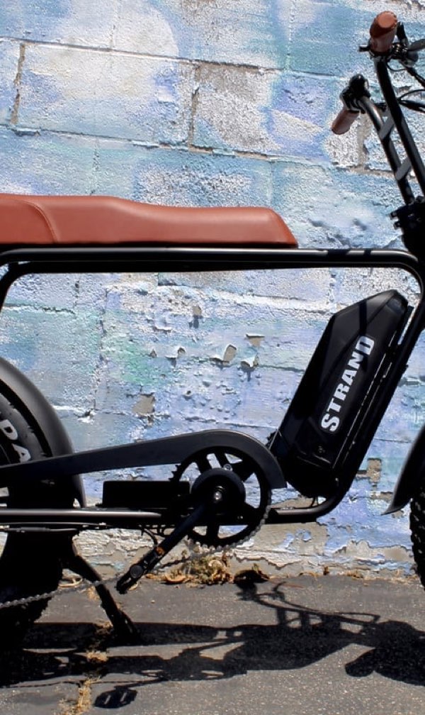 A black Strand moto e-bike with a tan bench seat.